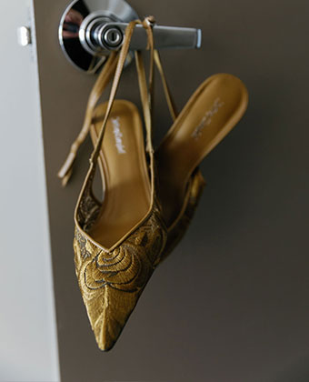 gold wedding shoes hanging on door